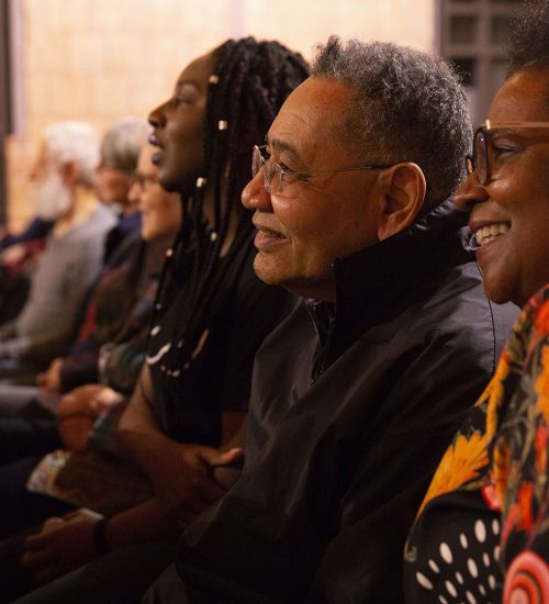 Three people looking off at a storyteller and smiling